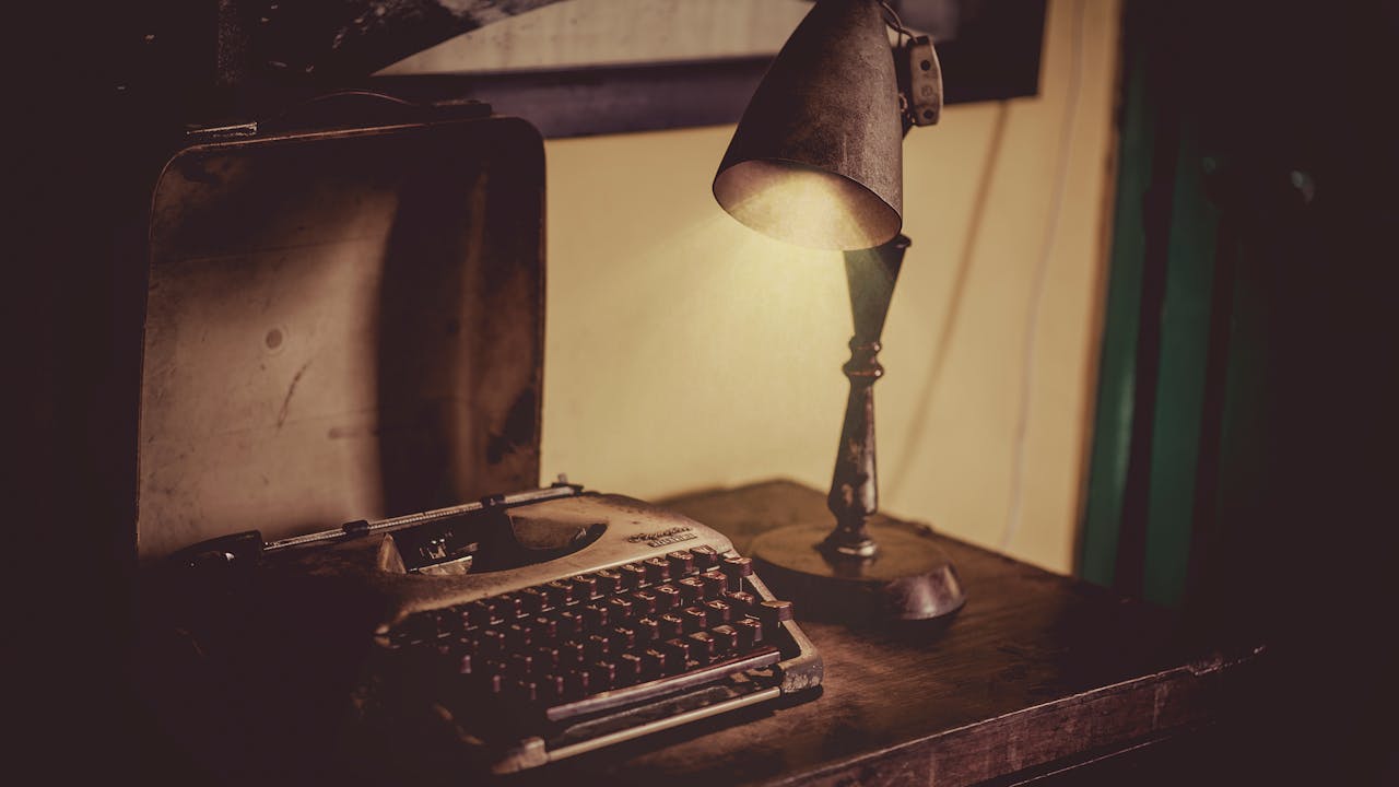 Cozy indoor setting with a vintage typewriter and antique lamp on a wooden desk, perfect for nostalgic themes.